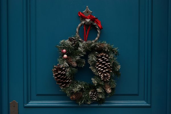 christmas wreath hangs on a navy blue door