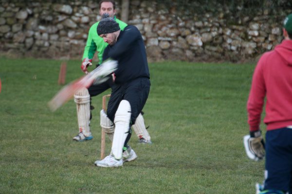 batsman in black tracksuit and hat hits out in the Yorkshire Dales cricket match