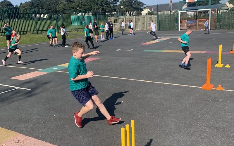 schoolchildren play cricket in the playground