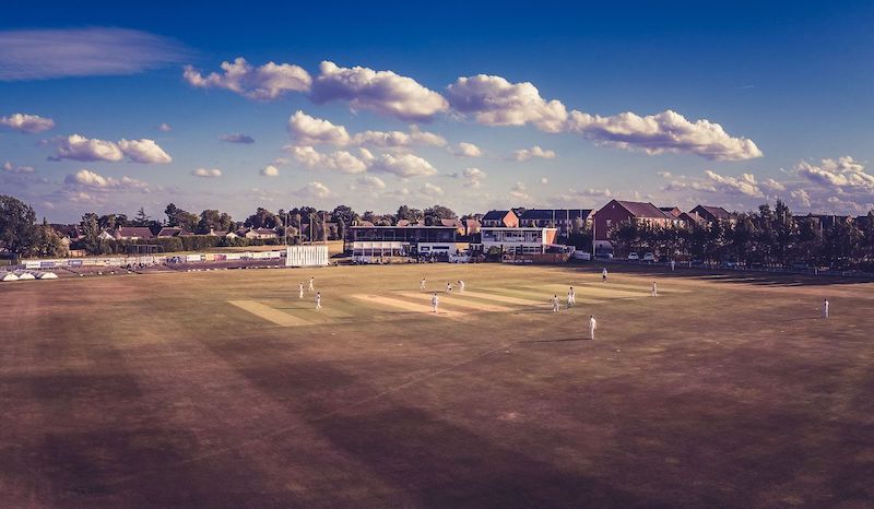 aerial photo of the main square using a drone to capture the white figures on a parched cricket ground in summer